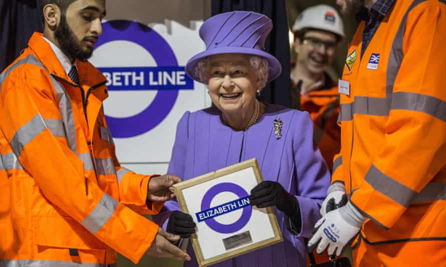 Queen Elizabeth holds a commemorative plaque given to her by Crossrail workers
