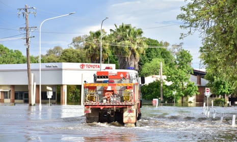 A NSW Rural Fire Service truck ferries essential workers through flood waters in Forbes