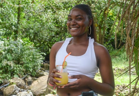 A young member of the Association of Black and Indigenous Peasant Women of Buenaventura holds a cocktail made with viche
