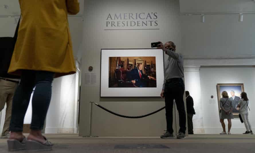 Un homme prend un selfie avec la photo de Trump à la National Portrait Gallery.
