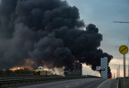 Smoke rising over high-rise buildings at dawn in Kyiv