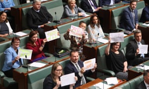 Federal Labor MPs hold up signs supporting AAP in the House of Representatives in Canberra on Tuesday after the wire service’s June closure was announced