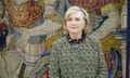 Hillary Clinton standing in front of a tapestry