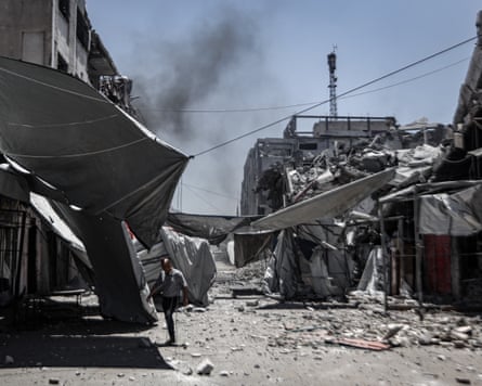 A man walks among rubble and destroyed buildings