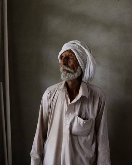 An old Indian man with a beard in a turban looks off to one side