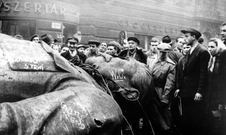People gather around a fallen statue of Soviet leader Josef Stalin in front of the National Theater in Budapest, Hungary, in this Oct. 24, 1956 file photo. (AP Photo/Arpad Hazafi, file) history crowd