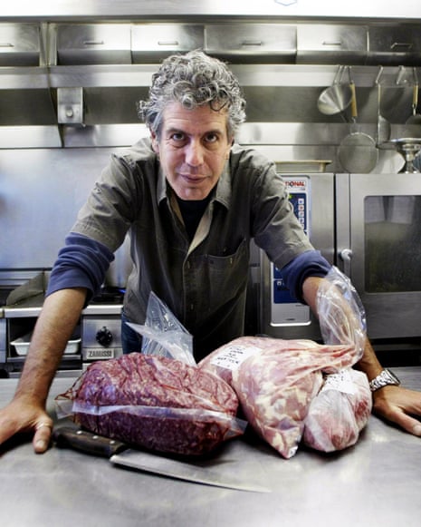 A chef standing in front two huge slabs of meat on a silver table