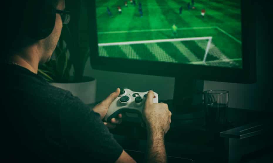 Gamer playing football game with video controller.