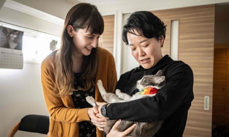 Partners Katie and Miki play with their cats at their Tokyo home.