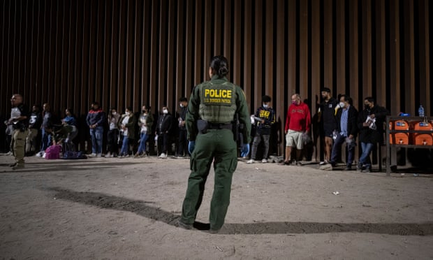 Hundreds of migrants cross the US-Mexico border in Yumaepa10026783 A US Border Patrol officer looks at migrants lining up against 'the wall' before processing them as hundreds cross the border between Mexico and the US in Yuma, Arizona, USA, 20 June 2022 ( issued June 21, 2022). Coming from all over the world, most of the migrants who cross the border where the wall ends at the limit of the Cocopah Indian Reservation, willingly turn themselves to US Border Patrol officers who will process them as they ask for asylum. EPA/ETIENNE LAURENT ATTENTION: This Image is part of a PHOTO SET