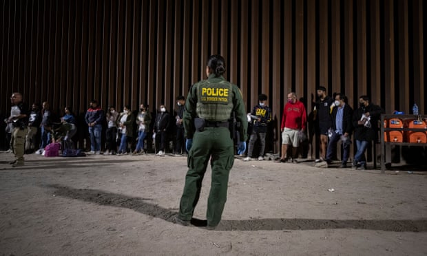 Yüzlerce göçmen Yumaepa'da ABD-Meksika sınırını geçiyor10026783 Bir ABD Sınır Devriyesi memuru, 20 Haziran 2022'de Yuma, Arizona, ABD'de Meksika ve ABD arasındaki sınırı geçerken onları işlemeden önce 'duvara' karşı sıraya giren göçmenlere bakıyor ( 21 Haziran 2022'de yayınlandı).  Dünyanın dört bir yanından gelen göçmenlerin çoğu, duvarın bittiği yerde Cocopah Indian Reservation sınırında sınırı geçen göçmenlerin çoğu, kendilerini isteyerek, sığınma talebinde bulunduklarında onları işleme koyacak ABD Sınır Devriyesi görevlilerine çeviriyorlar.  EPA/ETİENNE LAURENT DİKKAT: Bu Resim bir FOTOĞRAF SETİNİN parçasıdır