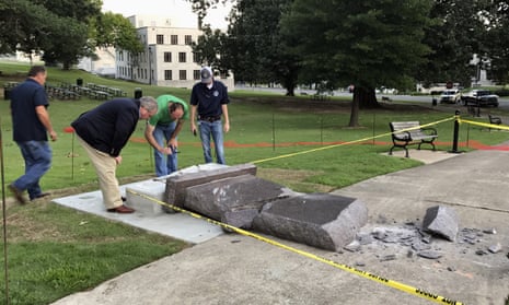 Workers inspect the damage to the Ten Commandments monument outside the state capitol in Little Rock.