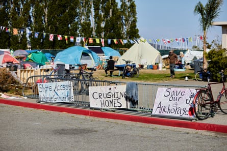 homeless encampment with signs that say 'save our anchorage' and 'stop crushing homes'