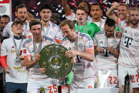 Bayern’s Thomas Müller and Harry Kane lift the Bundesliga trophy.