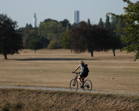 A person cycles through parched parkland in Birmingham, Britain.