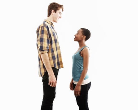 A very tall man looks down on a woman who is much shorter