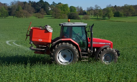 A red tractor moves through a field