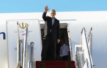 A man waves as he boards a plane.