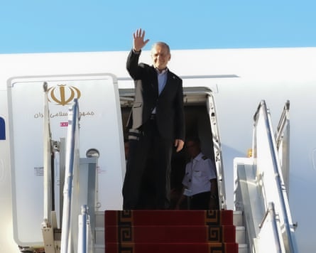 A man waves as he boards a plane.