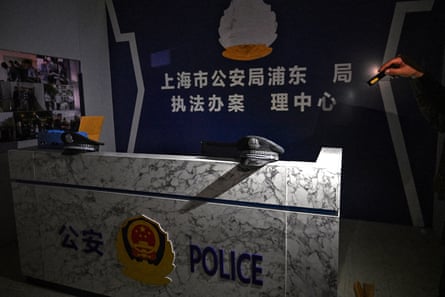 A police hat on a reception desk with Chinese writing and a police symbol on the wall behind