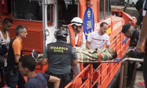 Rescue workers carry an injured Moroccan man on a stretcher at the port of Tarifa, southern Spain