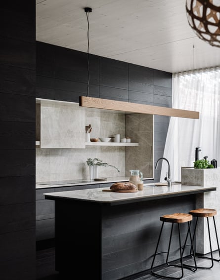 La cuisine présente des surfaces en chêne américain teinté noir et en marbre.