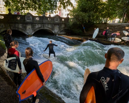 Surfers ride the Eisbach wave at the Englischer park