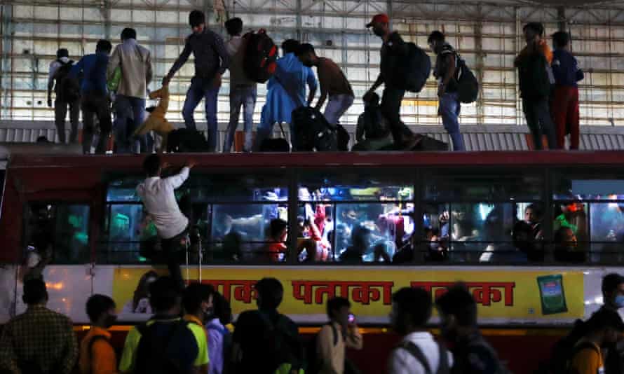 People climbing on top of a crowded bus