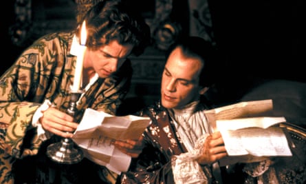 Peter Capaldi and John Malkovich, in a scene from Dangerous Liaisons in 1988, both dressed in period finery and both holding and looking at papers; Capaldi is also holding a candlestick with a lit candle.