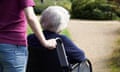 A woman pushes an older woman in a wheelchair