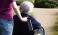 A woman pushing an older woman in a wheelchair