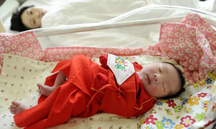 A mother sleeps beside her baby