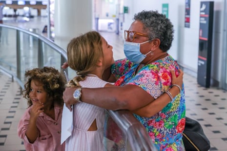 Margie Duckworth, one of the first passengers to arrive in Brisbane after international quarantine is removed, is greeted by family at Brisbane Airport