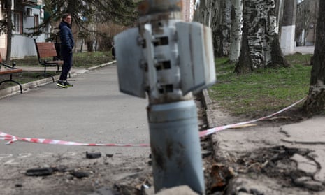 A man walks past an unexploded tail section of a 300mm rocket which appears to contain cluster bombs in Lysychansk, 11 April 2022. 