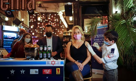 A woman receives a Covid vaccination in Tel Aviv, as part of an initiative offering a free drink at a bar to residents getting the shot