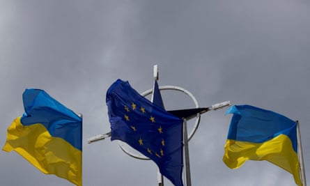 Flags of Ukraine and EU rise in front of the Nato emblem in central Kyiv.