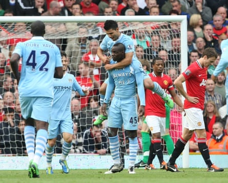 Mario Balotelli celebrates scoring for Manchester City against Manchester City at Old Trafford.