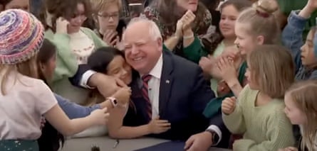 A middle-aged man smiles as children hig him.