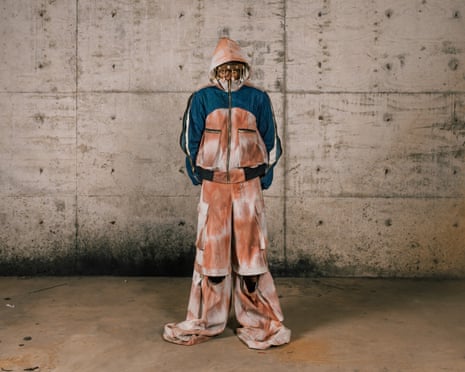 A model in a designer outfit featuring a multicoloured outsized tracksuit with hood and a shell-covered headband