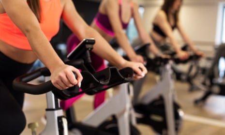 women on exercise bikes in gym