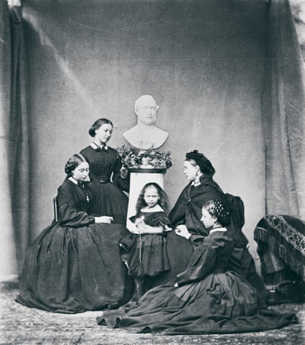 Photograph of Queen Victoria and her daughters clad in black, around a bust of Prince Albert.