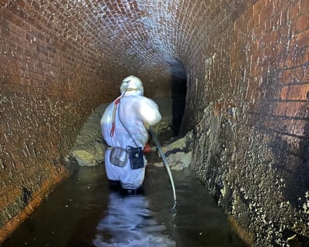 Person in hazmat suit in a Victorian sewer.