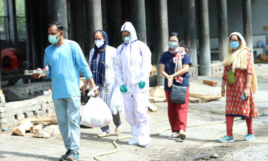Natasha Narwal (centre, in PPE coveralls), released from Tihar jail on interim bail.
