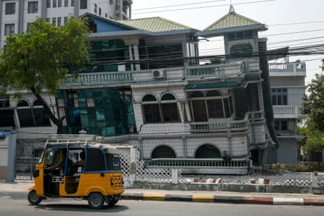 A tuk-tuk drives past a damaged building in Mandalay, a day after an earthquake struck central Myanmar.