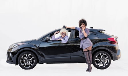 Drag queens Sasha and Brett with a Toyota in Santa Monica, California, US. The drag queens are dressed up and one is sitting in the front seat while the other is leaning against the car