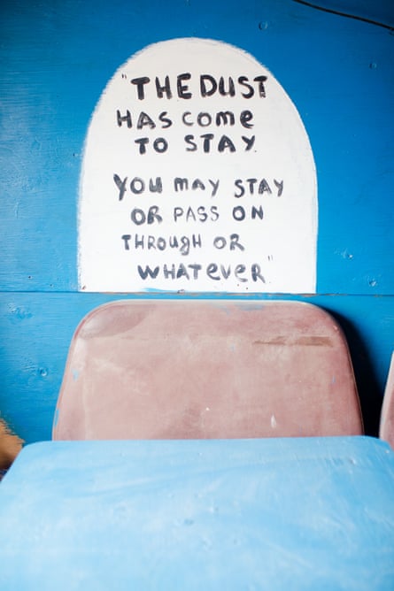 A wall painting that says “The dust has come to stay you may stay or pass on through or whatever”