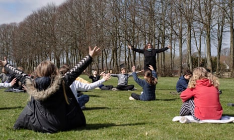 A teacher holds a music lesson outdoors with her class at the Korshoejskolen school, after it reopened following the lockdown due to the coronavirus outbreak, in Randers, Denmark