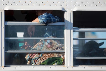 A temporary agricultural worker looks out the window of a bus near the port of entry in San Luis, Arizona
