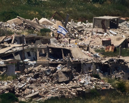 An Israeli flag flies above a destroyed building in southern Lebanon