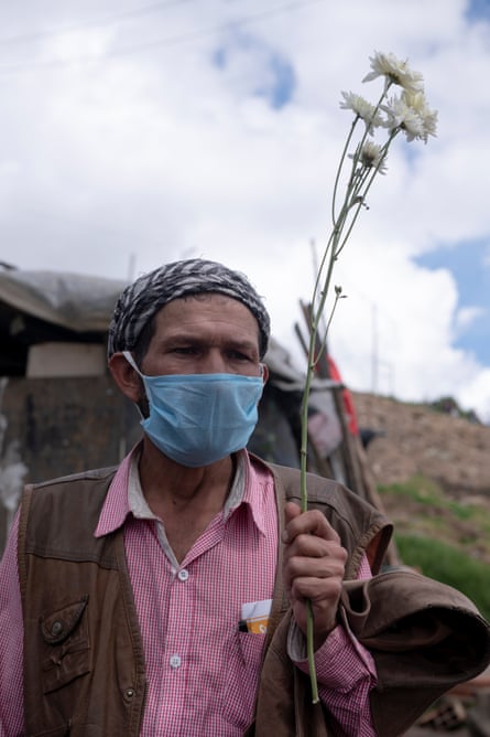 Don Pacho, 55, with a flower from his garden near his house at La Ville Nue in Bogotá on 29 May. He is an inhabitant of Altos de la Estancia. Authorities tore down 70% of his house.